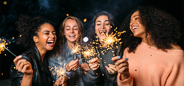 4 women celebrating a new year with sparklers