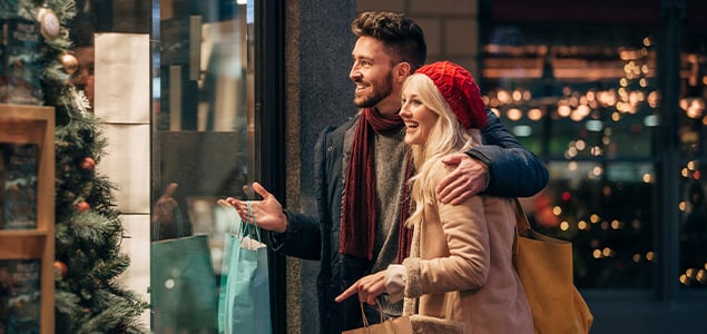 An image of a man and woman couple window shopping at holiday time