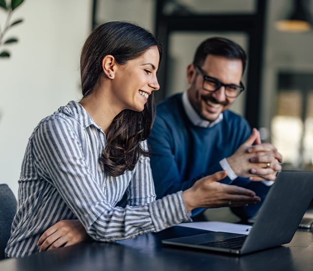 man and woman looking at laptop together