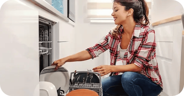 an image of a woman loading a plate into a dishwasher