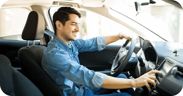an image of a man sitting the driver's seat of a car tuning to a radio station