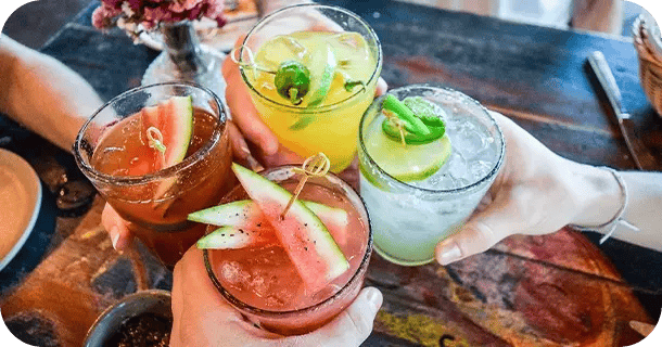 an image of a group of four people cheers-ing with beverages