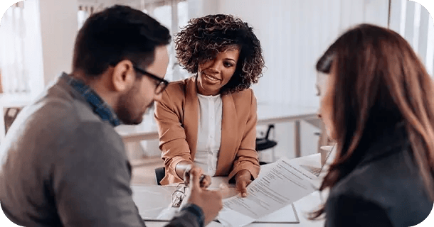 an image of a woman discussing paperwork with a couple