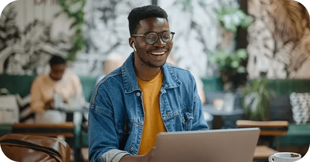 an image of a man sitting in a cafe working on his computer