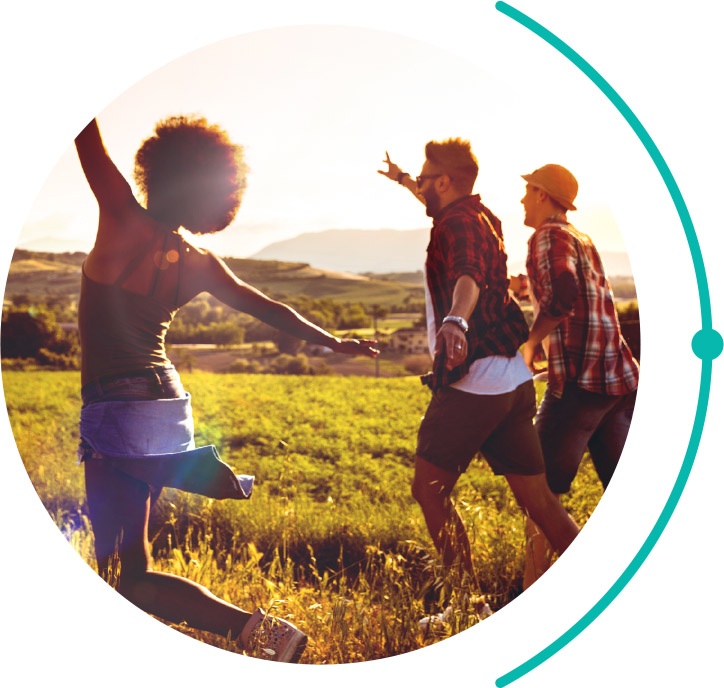three friends running through a field