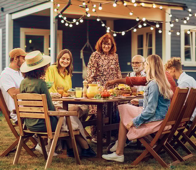 multigenerational family enjoy meal in backyard