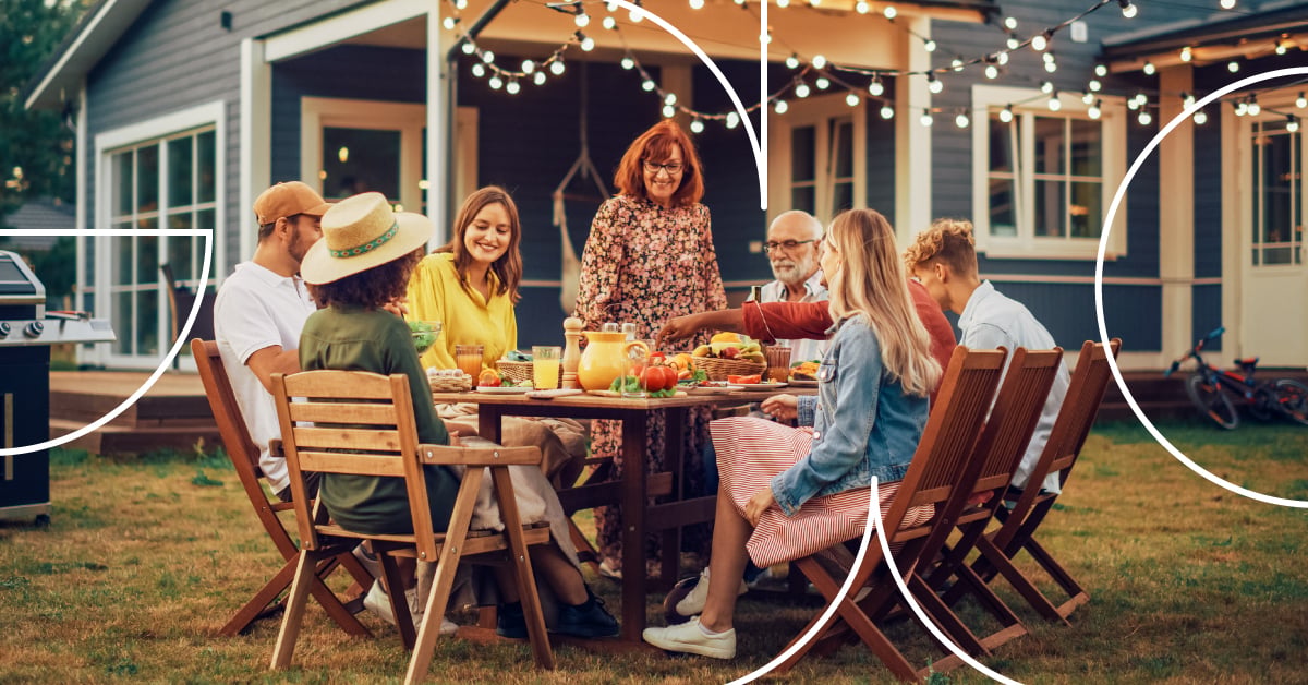 Group of people gathered around an outdoor table at a home setting, representing everyday lifestyle moments and family life.